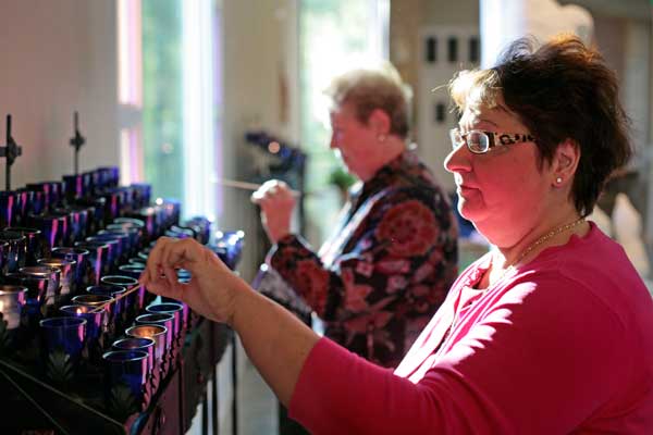 Lydia Scrafano, right, lights a candle in St. Bede's Catholic Church in Williamsburg, Va. (RNS/USA Today/Jay Paul