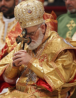 Melkite Patriarch Gregoire III Laham of Damascus, Syria, holds a crucifix as he prays during the closing Mass of the Synod of Bishops for the Middle East in St. Peter's Basilica at the Vatican Oct. 24. (CNS photo/Paul Haring)