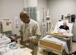 An oncology technician prepares an IV for a patient's chemotherapy. The U.S. bishop's Labor Day message for 20009 focuses on health care reform. (CNS file photo, 2008)
