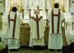 Bishop Edward J. Slattery of Tulsa, Okla., faces the crucifix on the altar as he celebrates Mass in early June at Holy Family Cathedral.
