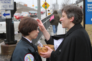 The Rev. Kara Wagner Sherer of St. John's Episcopal Church in Chicago gives ashes to a passerby in 2011 as part of a growing "Ashes to Go" program in the Episcopal church. (RNS/courtesy Canticle Communications)