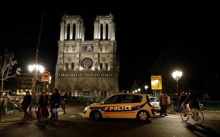 A police car is seen outside Notre Dame Cathedral as people leave after a Mass celebrated by Paris Cardinal Andre Vingt-Trois in Paris Nov. 15 to pray for those killed in terrorist attacks. Coordinated attacks the evening of Nov. 13 claimed the lives of 129 people. (CNS photo/Paul Haring)