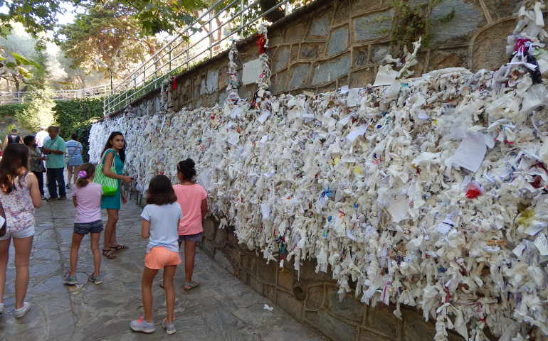 Pilgrims to the House of Mary write petitions on strips of paper and tie them in knots to the Meryemana Wishing Wall at the front of the house. 