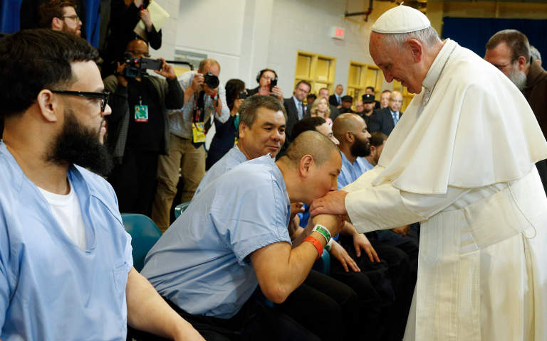 A prisoner kisses the hand of Pope Francis as he visits the Curran-Fromhold Correctional Facility in Philadelphia Sept. 27. (CNS/Paul Haring) 