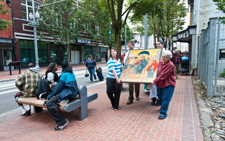Residents watch as people carry an icon from the St. Vincent de Paul Chapel in late August through the streets of downtown Portland, Ore. The icon is meant to show Jesus' outreach to the poor and mentally ill. (CNS/Catholic Sentinel/Kim Nguyen)