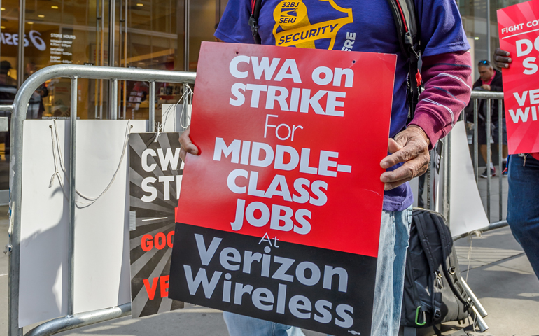 A man walks in the striking Verizon workers' picket line outside a store in New York May 12. (Pacific Press/Erik McGregor)