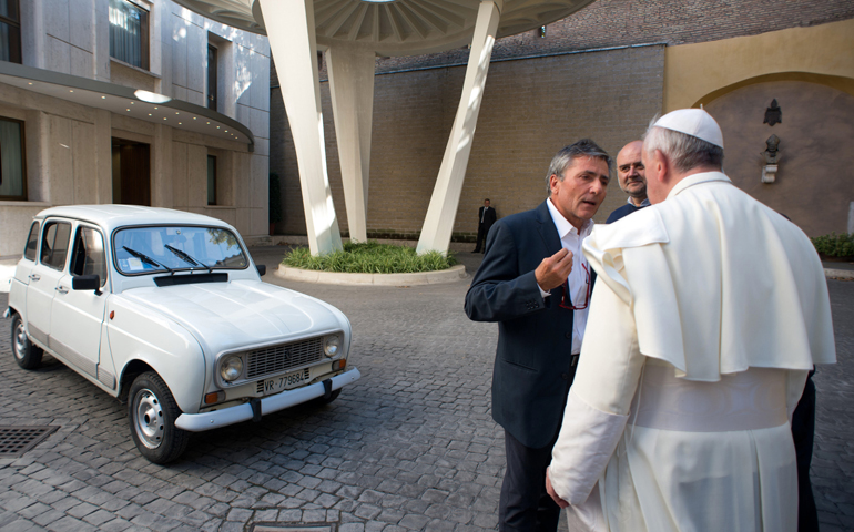 Pope Francis accepts a gift of a 1984 Renault on Saturday at the Vatican. The silver-white four-door vehicle with 186,000 miles was donated by Fr. Renzo Zocca of Verona, Italy. (CNS/L'Osservatore Romano via Catholic Press Photo)