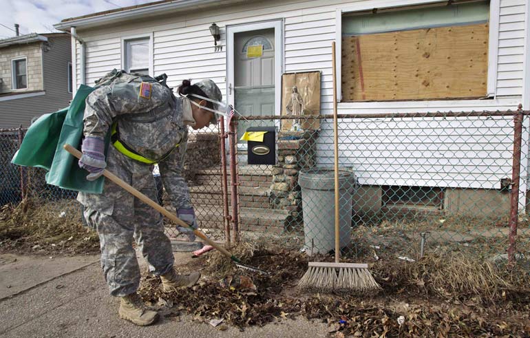 A statue of Mary is seen in front of a house as a member of the U.S. Army National Guard cleans up the front yard in the Staten Island borough of New York Nov.14. Staten Island was one of the hardest hit areas when Hurricane Sandy made landfall in late October. (CNS/Shannon Stapleton, Reuters)
