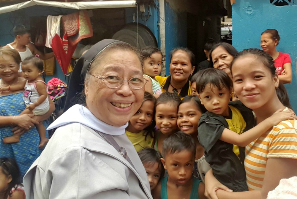 Missionary Benedictine Sr. Mary John Mananzan among people who live in a slum in the Philippines (Provided photo)
