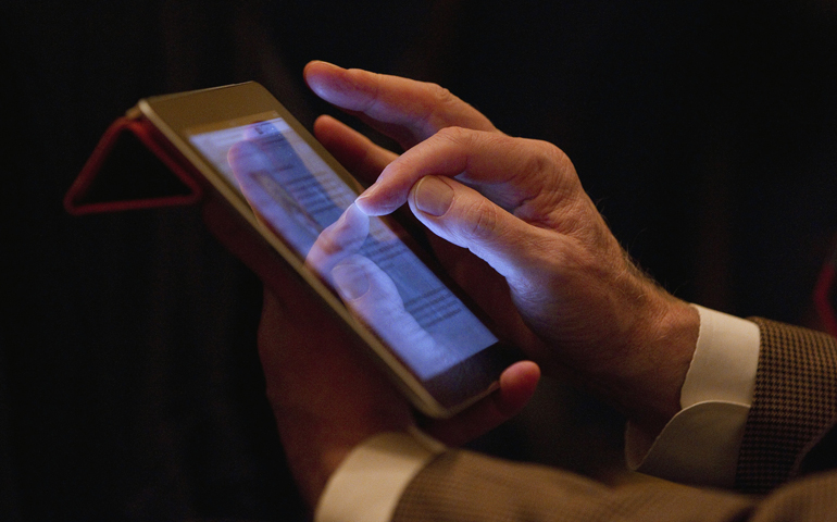 Peter Dwyer of Liturgical Press scrolls through a blog during a discussion between U.S. bishops and Catholics engaged in social media Sunday in Baltimore. (CNS/Nancy Phelan Wiechec)