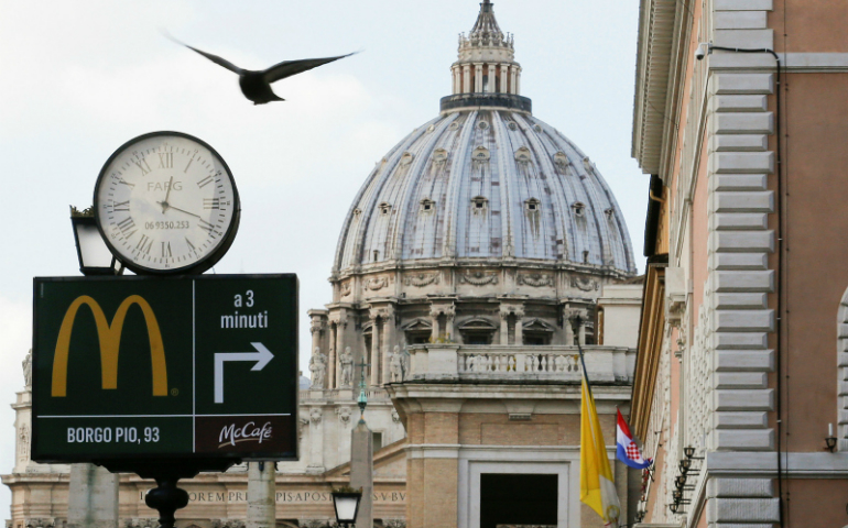 A sign in front of St. Peter's Basilica points to the newest McDonald's restaurant in Rome, next to the Vatican. Jan. 3, 2017. (Reuters/Alessandro Bianchi)
