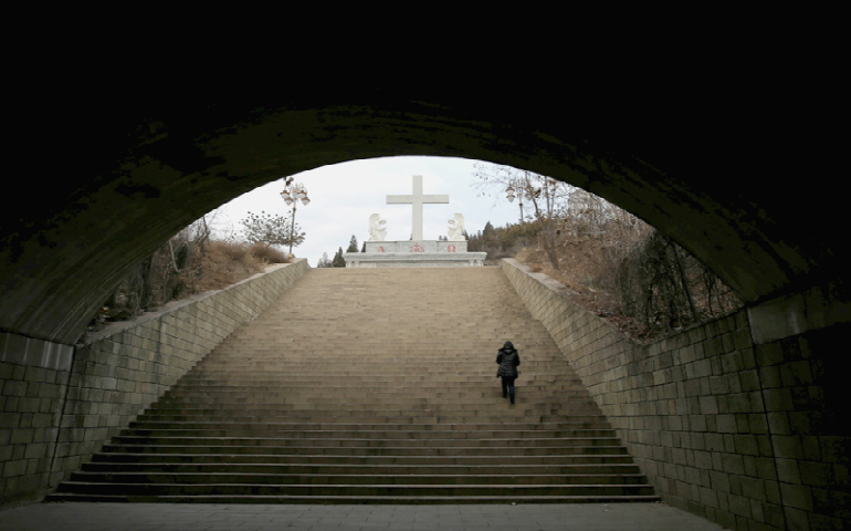 A villager climbs up the steps toward a cross near a Catholic church on the outskirts of Taiyuan, North China's Shanxi province, December 24, 2016. (REUTERS/Jason Lee)