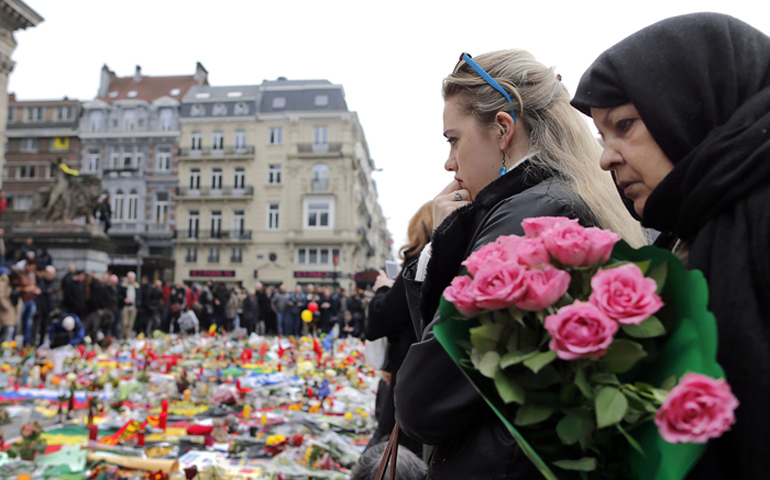 People observe a minute of silence at a street memorial to victims of Tuesdays’s bombings in Brussels, Belgium, on March 24, 2016. (Reuters/Christian Hartmann)