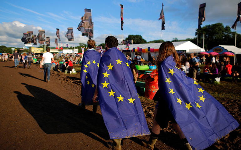 Revelers wrapped in European Union flags walk at Worthy Farm in Somerset during the Glastonbury Festival, Britain, on June 22, 2016. (Reuters/Stoyan Nenov)