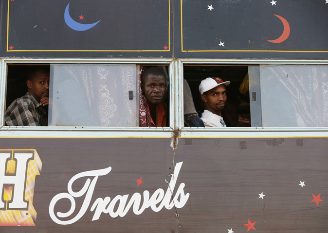 Men look out the bus windows to Nairobi, in Mandera town at the Kenya-Somalia border, on Dec. 6, 2014. (REUTERS/Goran Tomasevic)
