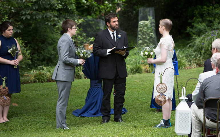 The Rev. Isaac Villegas, pastor of Chapel Hill Mennonite Fellowship, officiates at the wedding of Kate Dembinski to Kate Flynn on May 21, 2016. (Dan Scheirer)