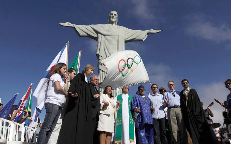 Brazilian officials and leaders of different religions pray next to the Olympic Flag in front of "Christ the Redeemer" statue during a blessing ceremony in Rio de Janeiro on Aug. 19, 2012. (Photo courtesy of REUTERS/Ricardo Moraes)