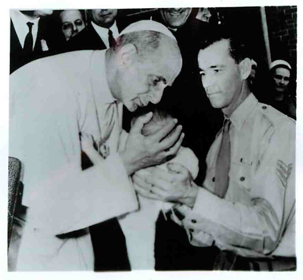 During a visit in Sydney, Pope Paul VI bends to kiss a baby held by his soldier father at the Royal Alexandra Hospital for Children in the Australian city. Religion News Service file photo.