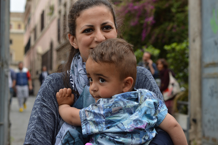 The youngest Syrian refugee aboard the papal plane was two-year-old Riyad, carried here by his mother Nour. (Religion News Service/Rosie Scammell)