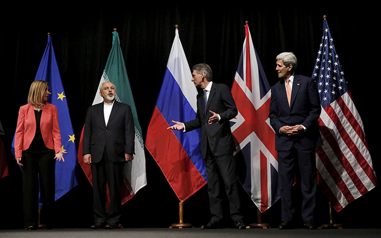 Left to right, European Union High Representative for Foreign Affairs and Security Policy Federica Mogherini, Iranian Foreign Minister Mohammad Javad Zarif, British Foreign Secretary Philip Hammond and U.S. Secretary of State John Kerry talk while waiting for Russian Foreign Minister Sergey Lavrov (not pictured) for a group picture at the Vienna International Center in Vienna on July 14, 2015. Iran and six major world powers reached a nuclear deal on July 14, 2015, capping more than a decade of on-off nego