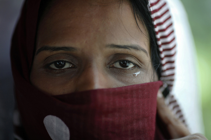 A Pakistani refugee, a member of the Ahmadiyya, an Islamic minority sect, cries as she leaves a detention center with her family on a bus in Bangkok on June 6, 2011. The Ahmadiyya community in Pakistan is often targeted in attacks by Islamic extremists. (Reuters/Damir Sagolj)