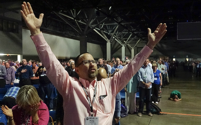 Phillip Herring, associate pastor of education at First Baptist Church in Norfolk, Virginia, raises his hands in prayer during the "National Call to Prayer for Spiritual Leadership, Revived Churches and Nationwide and Global Awakening" at the annual meeting of the Southern Baptist Convention on June 14, 2016, in St. Louis. (Courtesy of Baptist Press/Matt Miller)