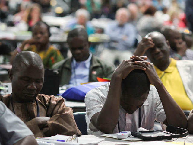 Delegates pray after the statement from Bishop Bruce R. Ough about sexuality and the church from the denomination's Council of Bishops on May 18 at the 2016 United Methodist General Conference in Portland, Ore. (Maile Bradfield/UMNS)