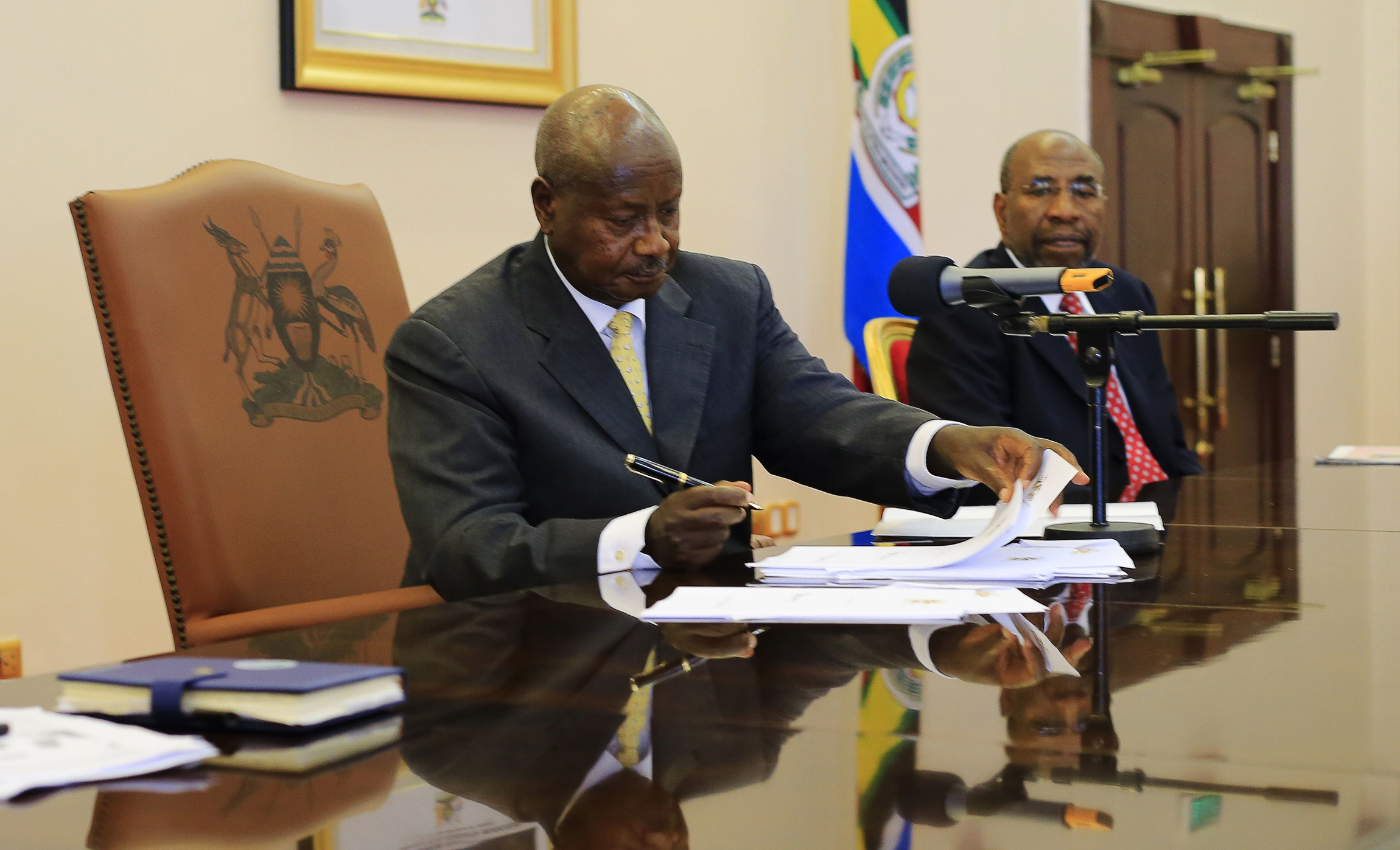 Uganda President Yoweri Museveni signs an anti-homosexuality bill into law in Entebbe Feb. 24. Uganda's Catholic bishops reaffirmed their opposition to homosexuality, but reserved judgment on the bill, which imposes harsh punishment for homosexual acts. (CNS photo/James Akena, Reuters) (Feb. 26, 2014)
