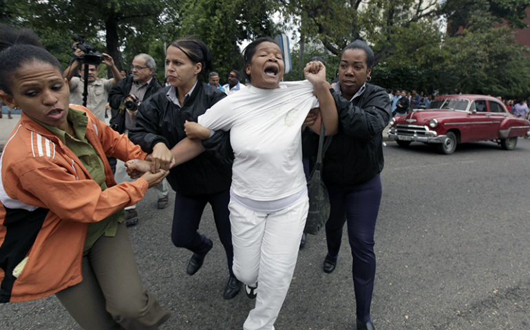 Cuban security personnel detain a member of the Ladies in White group during a protest on International Human Rights Day, in Havana, Cuba, on Dec. 10, 2014. (Reuters/Enrique De La Osa)