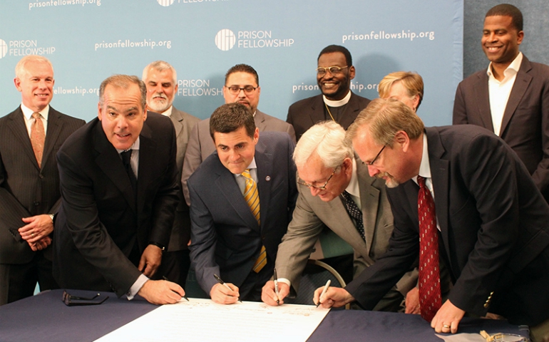 Leaders of evangelical organizations sign the "Justice Declaration," a statement by Christian leaders on criminal justice reform, in Washington, D.C., on June 20, 2017. Left to right, Prison Fellowship Ministries President James Ackerman, Southern Baptist ethicist Russell Moore, National Association of Evangelicals President Leith Anderson, and David Carlson of the Colson Center for Christian Worldview. (RNS/Adelle M. Banks)
