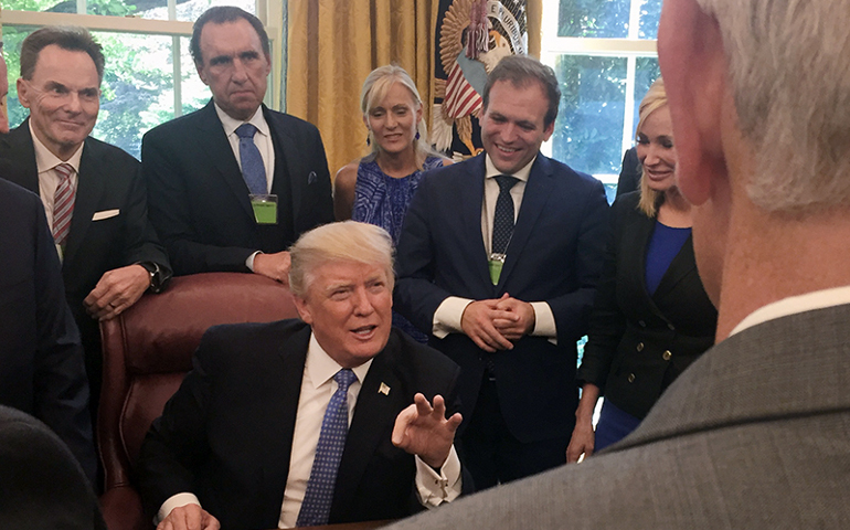 Ronnie Floyd, from left, Rodney Howard-Browne, Adonica Howard-Browne, Johnnie Moore, and Paula White stand behind President Trump as he talks with evangelical supporters in the Oval Office at the White House. (Photo courtesy of Johnnie Moore)