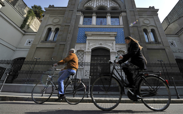 Two people ride bicycles past a synagogue in Milan, Italy, on March 15, 2012. (Reuters/Paolo Bona)