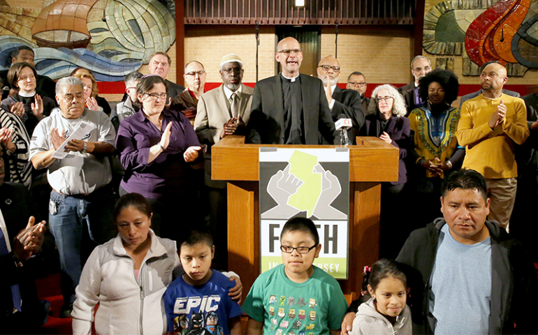 The Rev. John Mennell, center, invites clergy and others to come to the pulpit and stand for immigrants and to resist deportations as part of the Faith In New Jersey program at Bethany Baptist Church on May 4 in Newark, New Jersey. (NJ Advance Media/Aristide Economopoulos)