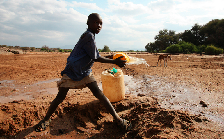 A child gathers water from a riverbed near Isiolo, Kenya, on July 30, 2013. (EU/ECHO/Martin Karimi)