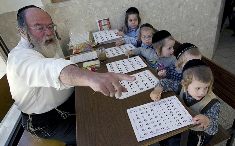 Ultra-Orthodox Jewish children sit in front of a teacher as they learn the alphabet at the Shomrei HaHoma Torah School for boys in Jerusalem's Mea Shearim neighborhood in Israel on Nov. 9, 2010. (Reuters/Ronen Zvulun)