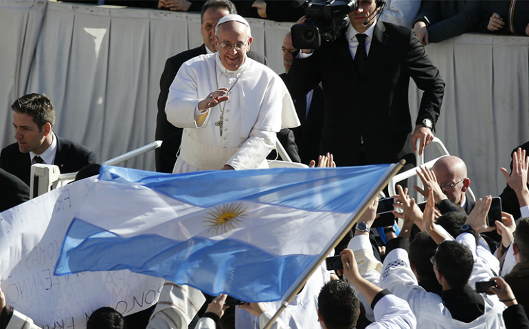 Pope Francis approaches priests with an Argentine flag as he arrives in St. Peter's Square for his inaugural Mass at the Vatican on March 19, 2013. (Reuters/Stefano Rellandini)