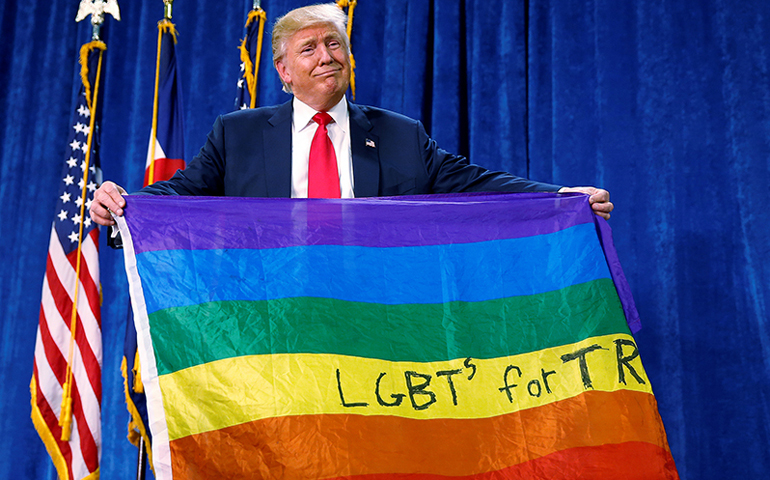 Donald Trump holds up a rainbow flag with "LGBTs for TRUMP" written on it at a campaign rally in Greeley, Colo., on Oct. 30, 2016. (Photo courtesy of Reuters/Carlo Allegri)