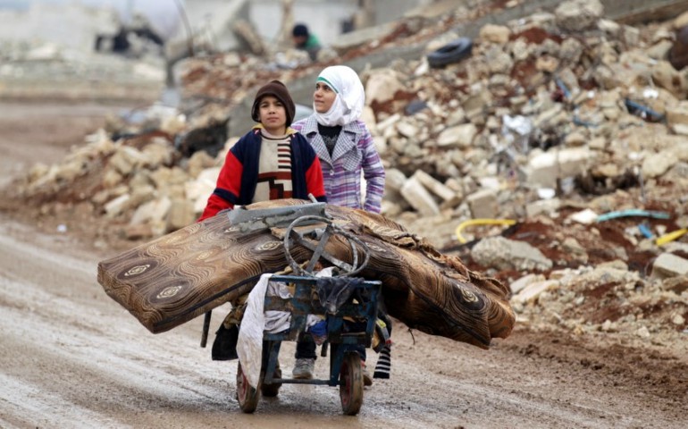 Syrian children transport their salvaged belongings from their damaged house in Doudyan, a village in northern Aleppo Jan. 2. (CNS/Reuters/Khalil Ashawi)