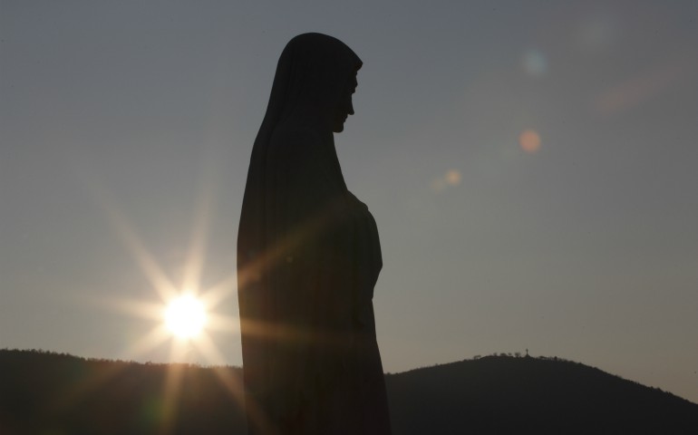 The sun sets behind a statue of Mary on Apparition Hill in Medjugorje, Bosnia-Herzegovina, in this 2011 file photo. (CNS photo/Paul Haring)