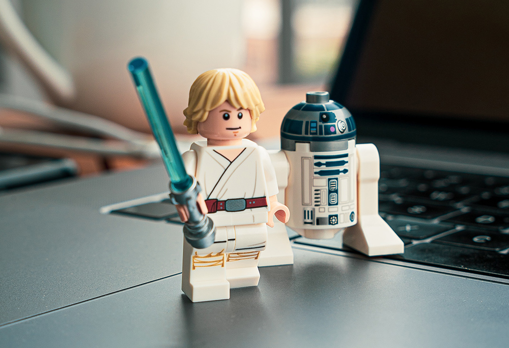 Lego "Star Wars" minifigures Luke Skywalker and R2-D2 are pictured. In "Star Wars," Luke receives a lightsaber at Obi-Wan Kenobi's hut on the planet Tatooine. Eric Clayton reflects on building a Lego set of the hut with his daughter. (Unsplash/Studbee)