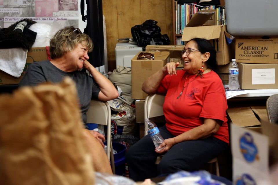 Joy Acosta, left, and Theresa Dardar talk in the Pointe-au-Chien Indian Tribe gathering center, which now doubles as an aid facility in Pointe-aux-Chenes, La., a month after Hurricane Ida made landfall. (AP/Jessie Wardarski)