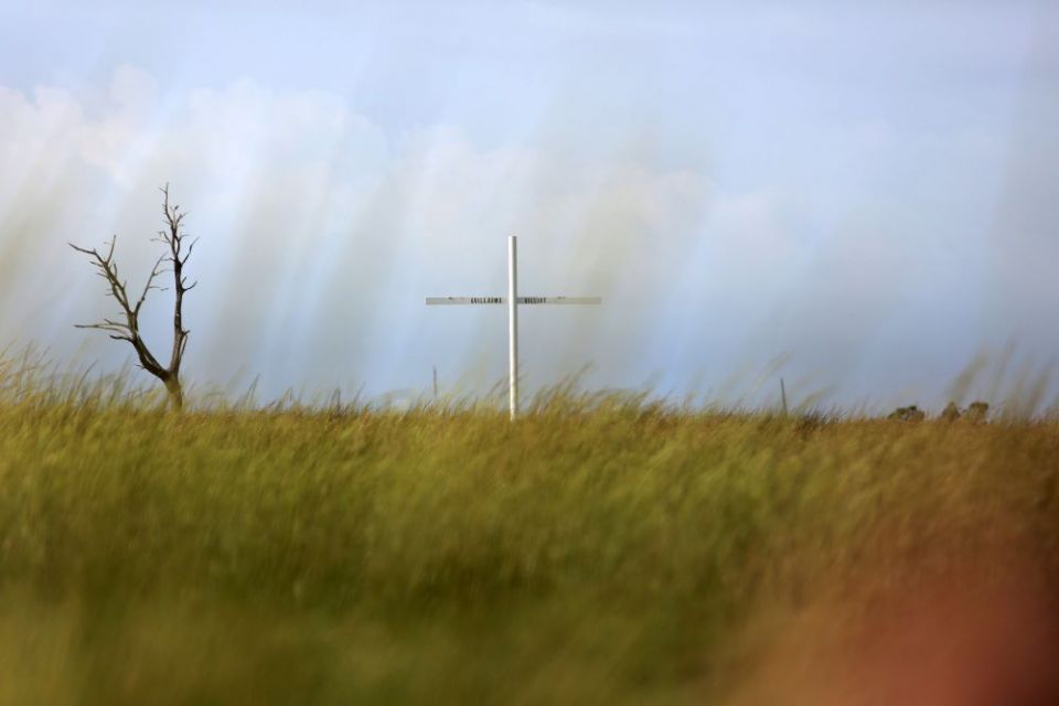 A cross marks one of several Pointe-au-Chien Indian Tribe burial grounds along Bayou Pointe-au-Chien in southern Louisiana. The cemetery is one of many sacred sites the community hopes to save from coastal erosion and sea level rise. (AP/Jessie Wardarski)