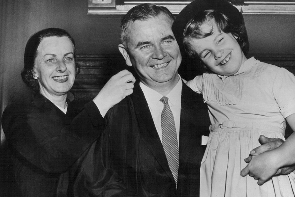 Justice William J. Brennan Jr. holds his daughter, Nancy, as his wife, Marjorie helps him with his robe at the Supreme Court building in this 1956 file photo. Brennan died July 24, 1997, at age 91. (CNS file photo)
