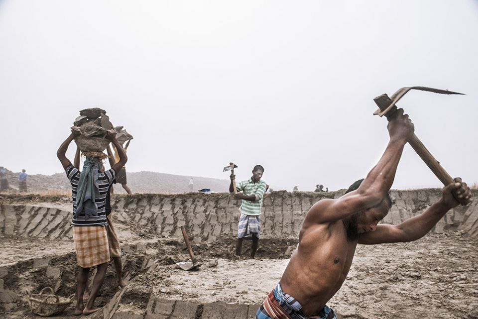 Workers rebuild a piece of low-lying land, or polder, on Monpura Island.