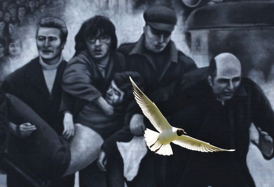 A seagull flies in front of a mural which shows a group of men, led by then-Fr. Edward Daly, right, carrying the body of shooting victim Jackie Duddy during 1972's Bloody Sunday in Derry, Northern Ireland. (CNS/Reuters/Cathal McNaughton) A seagull flies in front of a mural which shows a group of men, led by then-Fr. Edward Daly, right, carrying the body of shooting victim Jackie Duddy during 1972's Bloody Sunday in Derry, Northern Ireland. (CNS/Reuters/Cathal McNaughton)