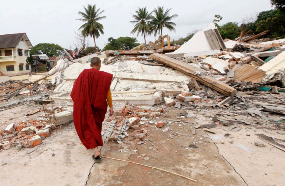 A Buddhist monk walks near a temple that was destroyed in an earthquake in Tarlay, Myanmar, March 27. (CNS/Reuters/Zoe Zeya Tun)