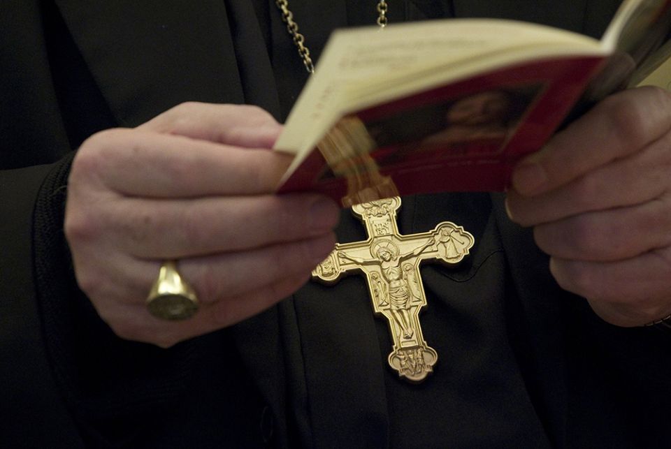 A bishop holds a prayer book during the morning prayer on the second day of the U.S. bishops' annual fall meeting in Baltimore Nov. 13, 2012. (CNS/Nancy Phelan Wiechec)