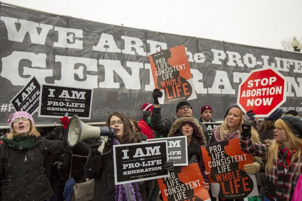 Kristan Hawkins, president of Students for Life of America, shouts pro-life slogans through a bullhorn in front of the Supreme Court building during the March for Life Jan. 25, 2014, in Washington. The groups will hold protests in seven cities throughout 