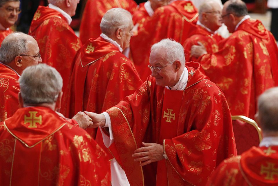 Cardinal Marc Ouellet exchanges a sign of peace with fellow cardinals during the Mass for the election of the Roman pontiff in St. Peter's Basilica at the Vatican March 12, 2013. (CNS/Paul Haring)