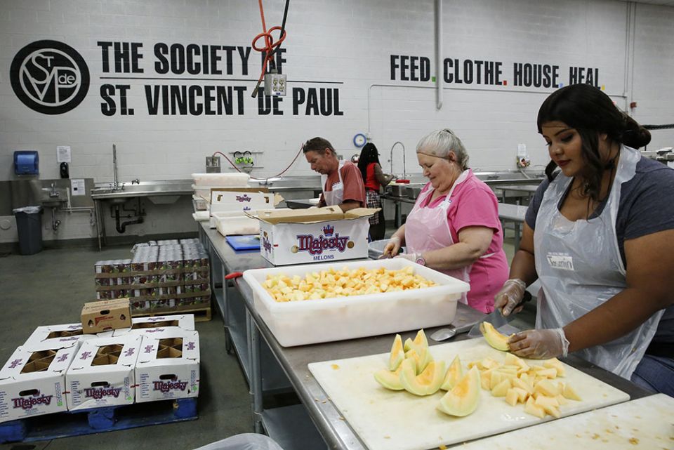 In the kitchen of the Society of St. Vincent de Paul in Phoenix in June 2016, volunteers prep food for struggling families and individuals. (CNS/Nancy Wiechec)